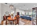 Open-concept living room and dining area with hardwood floors and a modern light fixture at 7890 Lake James Blvd, Lakeland, FL 33810