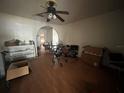 Empty living room with hardwood floors, ceiling fan and arched doorway at 801 Quintilian Ave, Orlando, FL 32809