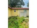 View of the home's side and rear, with a weathered exterior at 2220 Woods Trl, Lakeland, FL 33809