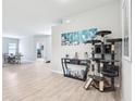 Spacious living room featuring wood-look floors, an entertainment center, and a decorative cat tree at 229 St Thomas Dr, Mulberry, FL 33860