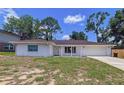 Inviting single-story home with a well-manicured front lawn, brick exterior, and an attached garage at 212 Overlook Dr, Winter Haven, FL 33884