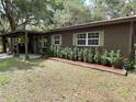 Charming single-story home with brown exterior, manicured landscaping, and neutral trim around the windows at 2748 Cr 543, Sumterville, FL 33585