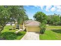Charming single-story home with a well-manicured lawn and mature trees at 413 Bay Leaf Dr, Poinciana, FL 34759