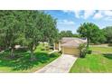 Charming single-story home with a well-manicured lawn and mature trees at 413 Bay Leaf Dr, Poinciana, FL 34759