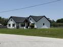 Beautiful exterior view of a modern farmhouse with white siding and a well-maintained lawn at 112 Cr 532B, Bushnell, FL 33513