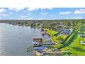 Picturesque aerial shot of a waterfront home with dock, showcasing lush greenery and expansive lake views at 390 Windermere Dr, Lakeland, FL 33809