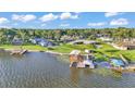 Scenic aerial view of waterfront property with a private dock, boat lift, and picturesque lake surroundings at 390 Windermere Dr, Lakeland, FL 33809