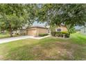 Cozy single-story home boasts a manicured lawn, a two-car garage, and pretty shrubs framing the walkway at 6898 Glenbrook Dr, Lakeland, FL 33811