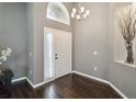Inviting foyer with dark wood floors, high ceilings, and a modern chandelier at 8360 Lake Amhurst Trl, Orlando, FL 32829