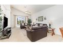 Bright living room featuring vaulted ceilings, comfortable leather sofas, glass tables, and a sliding glass door at 908 Andalusia Loop, Davenport, FL 33837