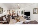 Cozy living room featuring vaulted ceilings, comfortable leather sofas, glass tables, and an entertainment center at 908 Andalusia Loop, Davenport, FL 33837