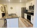 Modern kitchen featuring a granite island, stainless steel appliances, and white cabinets at 3974 Mekong Ct, St Cloud, FL 34772