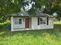 Charming single-story home with a front door flanked by large windows and green lawn at 408 S Orange Ave, Fort Meade, FL 33841