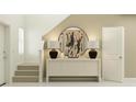 Inviting hallway with neutral tones, a decorative table with lamps, and a staircase leading to the upper level at 967 Hour Glass Rd, Lakeland, FL 33801