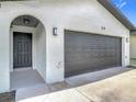 Charming home exterior with brick accents, dark gray garage door and inviting front porch at 34 Aaron Cir, Ormond Beach, FL 32174