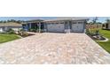 Long patterned brick driveway leading to a well-maintained two-car garage at 10298 Sw 96Th Loop, Ocala, FL 34481