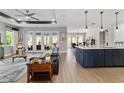 Open-concept living space with hardwood floors, a modern kitchen, and access to the outdoor space at 10298 Sw 96Th Loop, Ocala, FL 34481