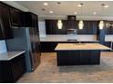 Modern kitchen features a large island, stainless steel appliances, white subway tile, and beautiful floors at 1521 Sourwood Dr, Ocoee, FL 34761