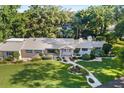 Aerial view of home with manicured landscaping, mature trees, and beautiful hardscape with a circular driveway at 2110 Reaney Rd, Lakeland, FL 33803
