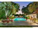 Inviting pool area with outdoor seating surrounded by lush tropical landscaping at 2110 Reaney Rd, Lakeland, FL 33803