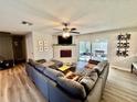 Comfortable living room with a brick fireplace, large sectional sofa, and sliding glass doors to the patio at 4128 Palo Alto Dr, Lakeland, FL 33813