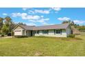 Attractive single-story home featuring a spacious green lawn and an extended roof design over the entrance at 21551 Lake Seneca Rd, Eustis, FL 32736