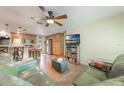 Open-concept living room with a kitchen view, comfortable seating, and a mounted television for entertainment at 21551 Lake Seneca Rd, Eustis, FL 32736