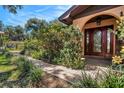 Close-up of front entry showcasing an arched entry, decorative sidelights, and manicured landscaping at 1625 Itchepackesassa Dr, Lakeland, FL 33810
