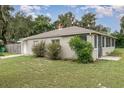 The backyard features a screened lanai with a concrete patio and lush landscaping, offering privacy and outdoor enjoyment at 130 E Pendleton Ave, Eustis, FL 32726
