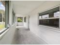 Enclosed lanai with multiple windows, concrete flooring and a white exterior door offers a bright transition to the outdoors at 130 E Pendleton Ave, Eustis, FL 32726