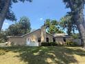 Expansive backyard with lush green lawn, mature trees, and a view of the home's exterior and fenced yard at 2921 Se 38 Pl, Ocala, FL 34480