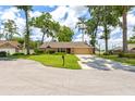 Inviting single-story home featuring a green lawn, mature trees, and a convenient driveway at 2921 Se 38 Pl, Ocala, FL 34480
