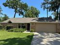 Charming single-story home with a well-manicured lawn, mature trees, and an attached two-car garage at 2921 Se 38 Pl, Ocala, FL 34480
