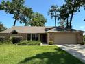 Charming single-story home with a well-manicured lawn, mature trees, and an attached two-car garage at 2921 Se 38 Pl, Ocala, FL 34480