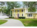 Inviting yellow two-story home featuring a covered porch, neat landscaping, and a curved driveway at 1226 Se 9Th Ave, Ocala, FL 34471