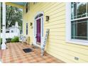 Charming front porch with brick tile flooring, a vibrant purple door, and a cozy seating area at 1226 Se 9Th Ave, Ocala, FL 34471
