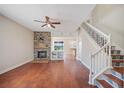Inviting living room with a stone fireplace, hardwood floors, and an open staircase at 2283 Geneva Dr, Lakeland, FL 33805
