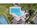 Aerial view of a community pool area with a large pool, lounge chairs, and a playground at 2283 Geneva Dr, Lakeland, FL 33805