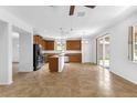 Open-concept kitchen with dark wood cabinetry, stainless steel appliances, a breakfast bar, and sliding glass doors at 1769 Strathmore Cir, Mount Dora, FL 32757