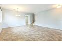 Spacious living area featuring tile flooring, a modern chandelier, and a staircase leading to the upper level at 1769 Strathmore Cir, Mount Dora, FL 32757