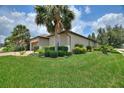 Well-maintained home showcasing green lawn, neat landscaping, mature palm trees, and a brick driveway at 224 Granada Ln, Davenport, FL 33837