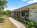 Charming exterior view of home featuring covered porch with brick columns and meticulous landscaping at 3100 Peacock Ln, Mulberry, FL 33860