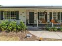 Inviting front porch with seating, flower planters, and a decorative wreath on the front door at 3100 Peacock Ln, Mulberry, FL 33860