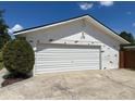 Detached garage with white siding and a large roll-up door, plus an adjacent fenced yard at 3100 Peacock Ln, Mulberry, FL 33860