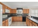Well-lit kitchen features wood cabinets, black countertops, tile backsplash, and modern appliances at 442 Graystone Blvd, Davenport, FL 33837