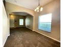 Inviting living room featuring fresh paint, carpet, arched doorways, and window with blinds at 10303 Park Commons Dr, Orlando, FL 32832
