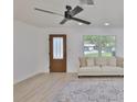 Bright living room featuring a ceiling fan, large window, and stylish area rug at 1110 Waterview E Blvd, Lakeland, FL 33801