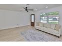 Bright living room featuring a ceiling fan, large window, and stylish area rug at 1110 Waterview E Blvd, Lakeland, FL 33801