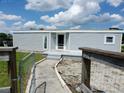 Home featuring gray siding, a walkway leading to the entrance, and rustic wooden and metal fencing at 1206 Skyview Cv, Lakeland, FL 33801