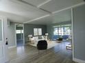Living room featuring light gray walls, wood flooring, modern furniture, and an enclosed porch area at 1206 Skyview Cv, Lakeland, FL 33801